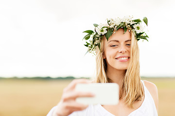 Image showing happy young woman taking selfie by smartphone