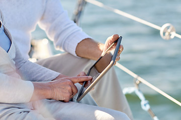 Image showing senior couple with tablet pc on sail boat or yacht