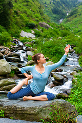 Image showing Sorty fit woman doing yoga asana outdoors at tropical waterfall