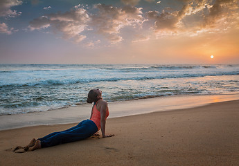 Image showing Woman practices yoga asana Urdhva Mukha Svanasana at the beach