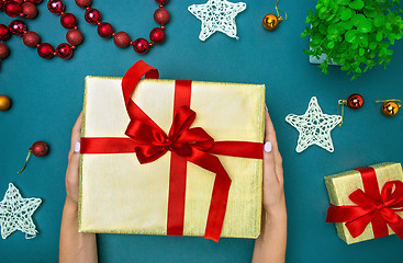 Image showing Hands of woman and Christmas gift box.