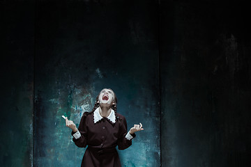 Image showing Portrait of a young smiling girl in school uniform as killer woman