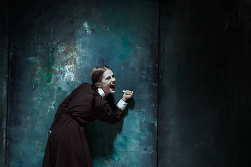 Image showing Portrait of a young smiling girl in school uniform as killer woman