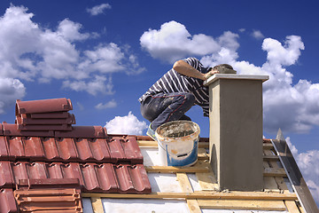 Image showing Roofer builder worker repairing a chimney stack on a roof house