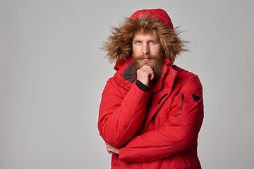 Image showing Pensive bearded man in red winter jacket