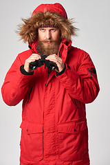 Image showing Man wearing red winter jacket with binoculars