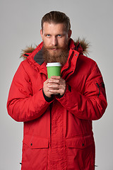 Image showing Man in red winter jacket with cup of hot drink