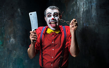 Image showing The scary clown holding a knife on dack. Halloween concept