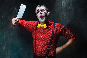 Image showing The scary clown holding a knife on dack. Halloween concept