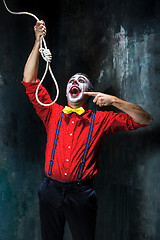 Image showing The scary clown and rope for hanging on dack background. Halloween concept