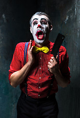 Image showing The scary clown holding a knife on dack. Halloween concept