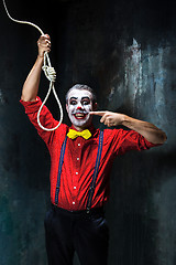 Image showing The scary clown and rope for hanging on dack background. Halloween concept