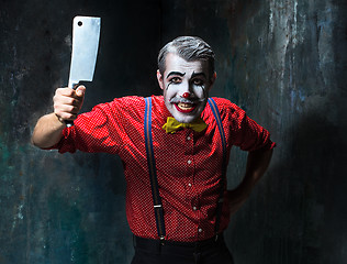 Image showing The scary clown holding a knife on dack. Halloween concept