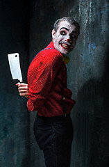 Image showing The scary clown holding a knife on dack. Halloween concept