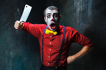 Image showing The scary clown holding a knife on dack. Halloween concept