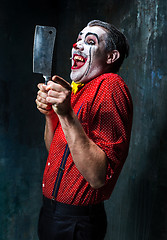 Image showing The scary clown holding a knife on dack. Halloween concept