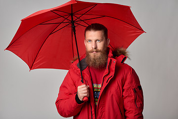 Image showing Man in red winter jacket standing with umbrella