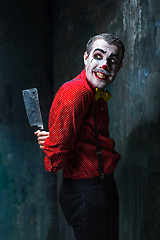 Image showing The crazy clown holding a knife on dack. Halloween concept