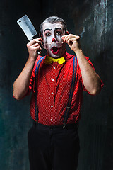 Image showing The scary clown holding a knife on dack. Halloween concept