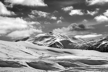 Image showing Black and white ski slope and beautiful sky with clouds in sun e