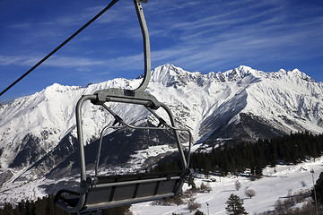 Image showing Chair-lift at ski resort and snow winter mountains in nice sun d