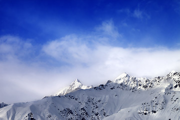 Image showing Snow sunlight mountain peak in fog and blue sky