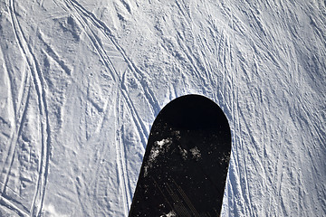 Image showing Snowboard over off-piste slope with track from ski and snowboard