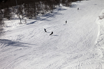 Image showing Skiers and snowboarders on ski slope at sun winter day