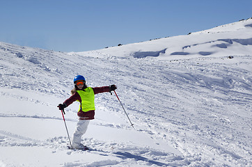 Image showing Little skier on ski slope with new fallen snow at sun day