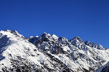 Image showing Snowy rocks and blue clear sky at cold sun day