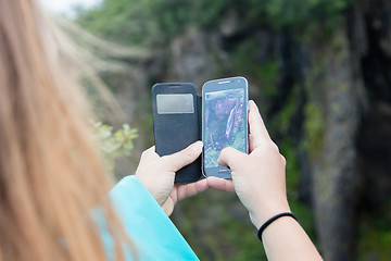 Image showing Woman photographing a waterfall with a mobile phone