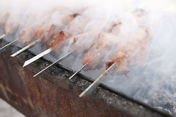 Image showing Grilling marinated shashlik on a grill. Shish kebab popular in Eastern, Central Europe and other places. 