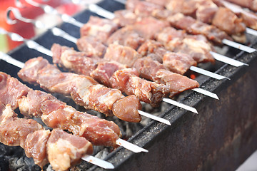 Image showing Grilling marinated shashlik on a grill. Shish kebab popular in Eastern, Central Europe and other places. 
