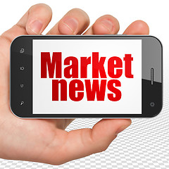 Image showing News concept: Hand Holding Smartphone with Market News on display