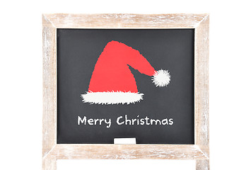 Image showing Christmas greetings with Santas hat on blackboard