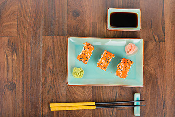 Image showing Sushi rolls on the wooden table. Overhead view