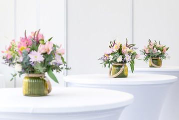 Image showing beautiful flower arrangement on white festive tables