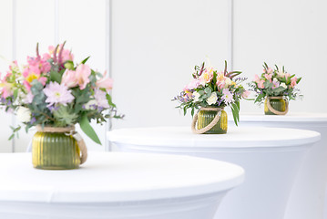 Image showing beautiful flower arrangement on white festive tables