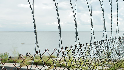 Image showing Sea behind barbed wire 