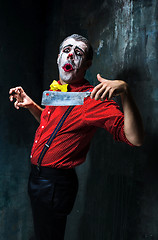 Image showing The crazy clown holding a knife on dack. Halloween concept