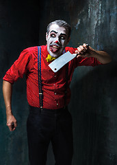 Image showing The crazy clown holding a knife on dack. Halloween concept