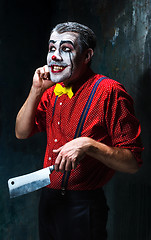 Image showing The crazy clown holding a knife on dack. Halloween concept