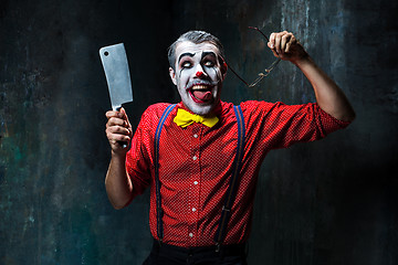 Image showing The scary clown holding a knife on dack. Halloween concept