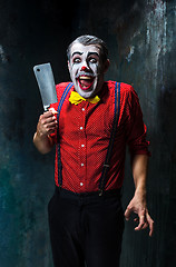 Image showing The scary clown holding a knife on dack. Halloween concept