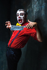 Image showing The crazy clown holding a knife on dack. Halloween concept