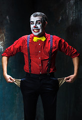 Image showing Terrible clown and Halloween theme: Crazy red clown in a shirt with suspenders on a dark background