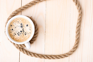 Image showing Cup of coffee with foam on wooden table