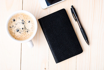 Image showing Smartphone with notebook and cup of strong coffee