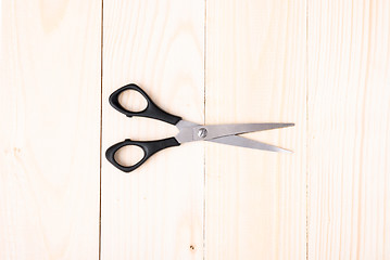 Image showing Scissors on wooden background