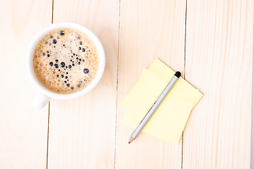 Image showing Wood desk with office supplies and cup of coffee